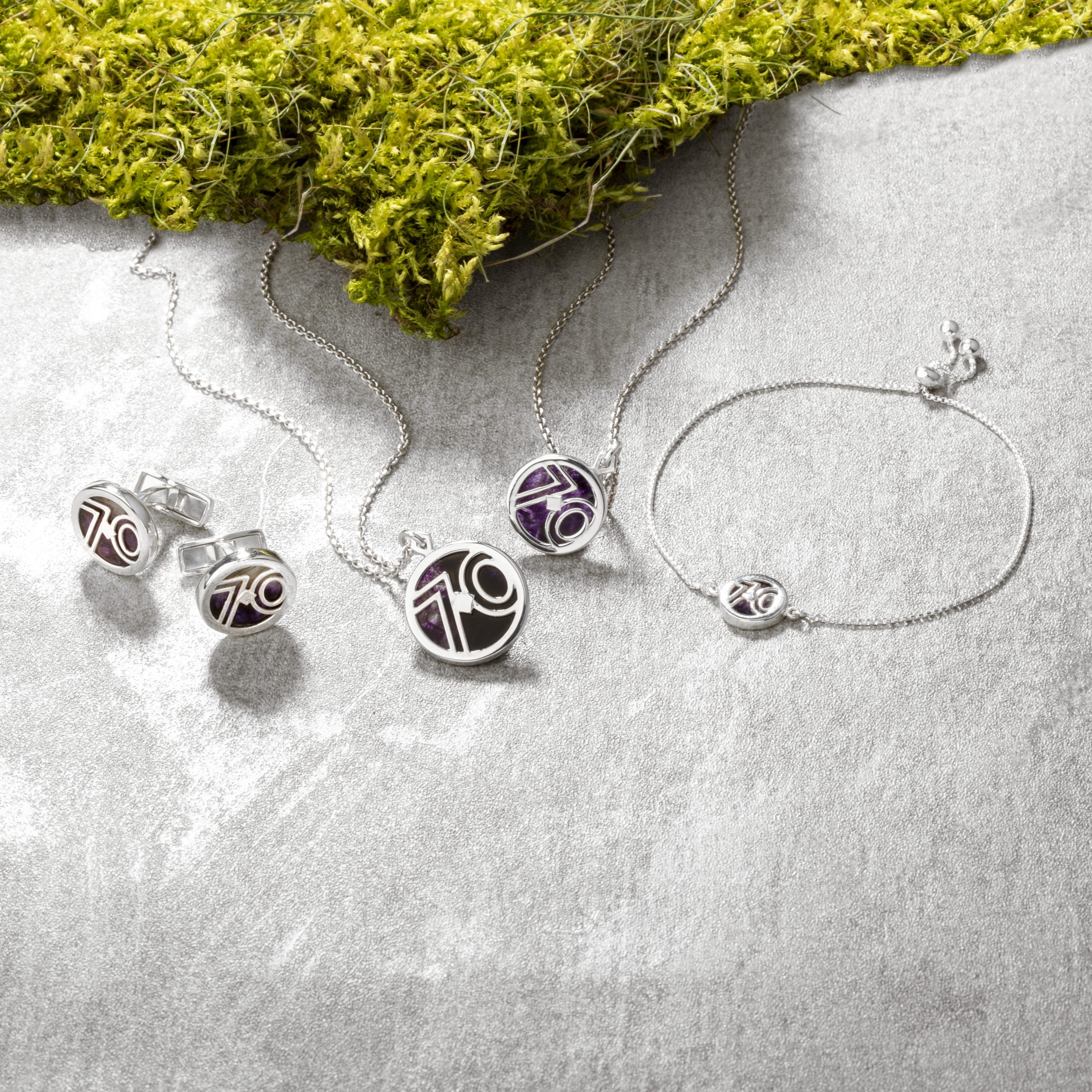 Blue John and silver jewellery on a stone and moss background