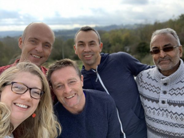 trustees of the Peak District National Park Foundation gather in a group on black rocks in Wirksworth